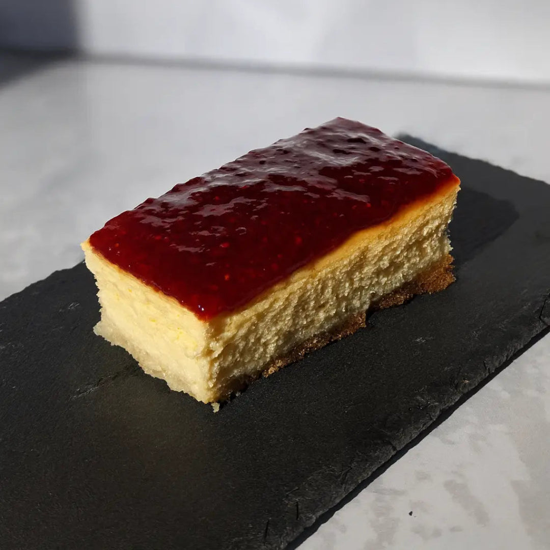 Cheesecake keto premium con base de almendras y mermelada natural de frutos rojos.