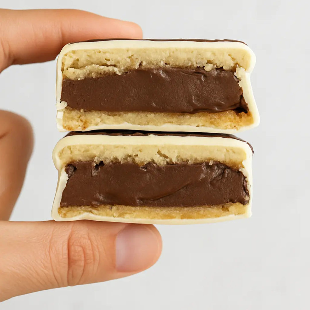 Alfajor keto relleno de ganache de chocolat e85% bañado en chocolate blanco, sin guten ni azucar, bajo en carbos