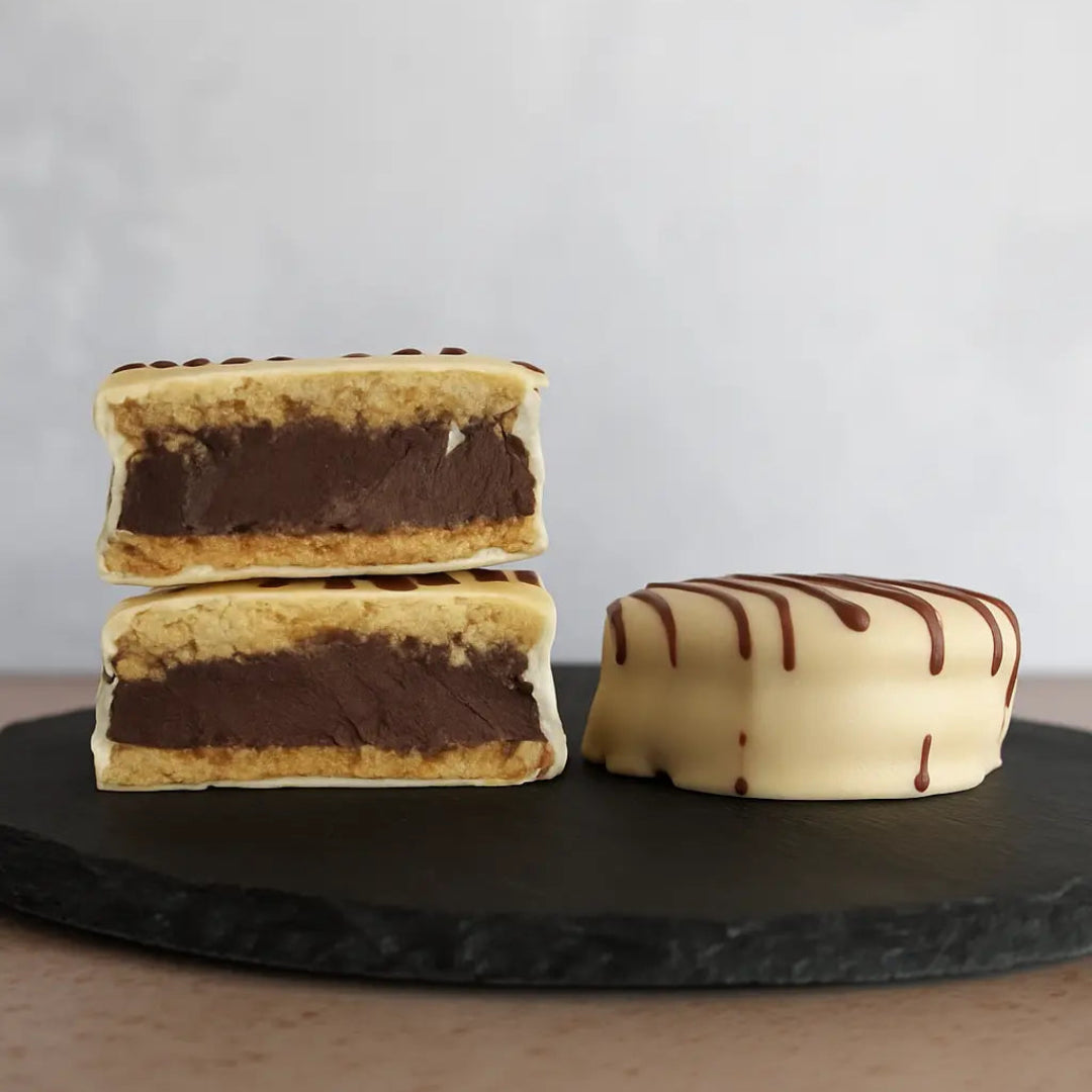 Alfajor keto relleno de ganache de chocolat e85% bañado en chocolate blanco, sin guten ni azucar, bajo en carbos
