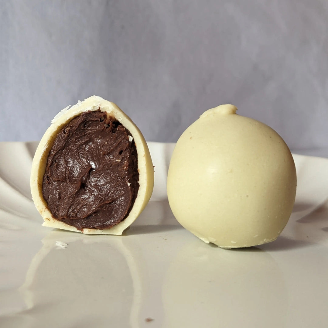 Bombón keto saludable con ganache de chocolate y cobertura blanca.